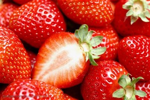 新鲜水果-在水果堆中间摆放的半边新鲜草莓特写