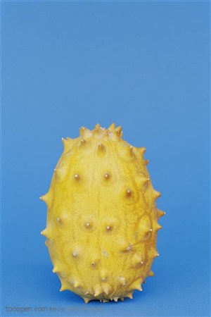 新鲜水果-一个竖着摆放的带刺的黄色果皮水果