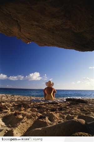 坐在岩石上看海的女人