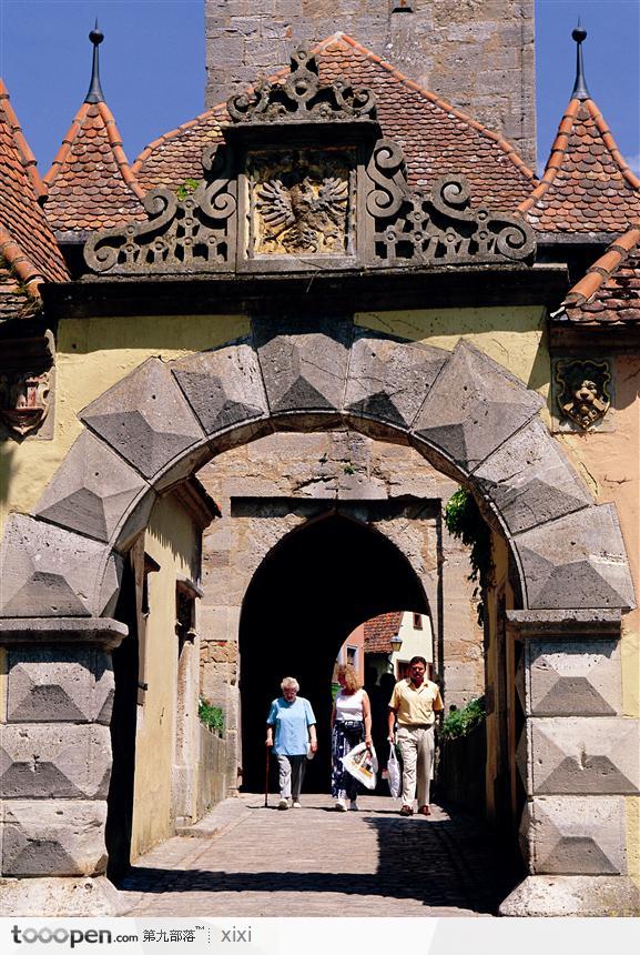 古堡下的门和游人雕塑