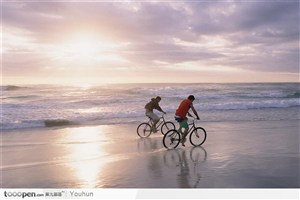 两个人海滩上骑自行车