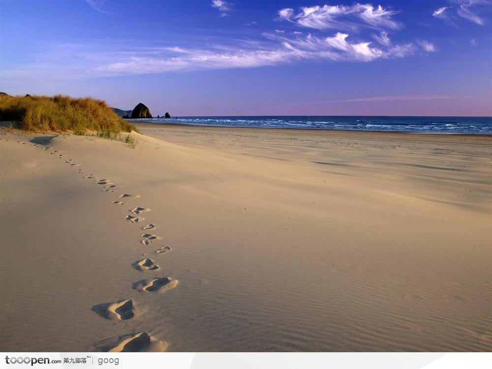 蓝天下的大海沙滩与脚印