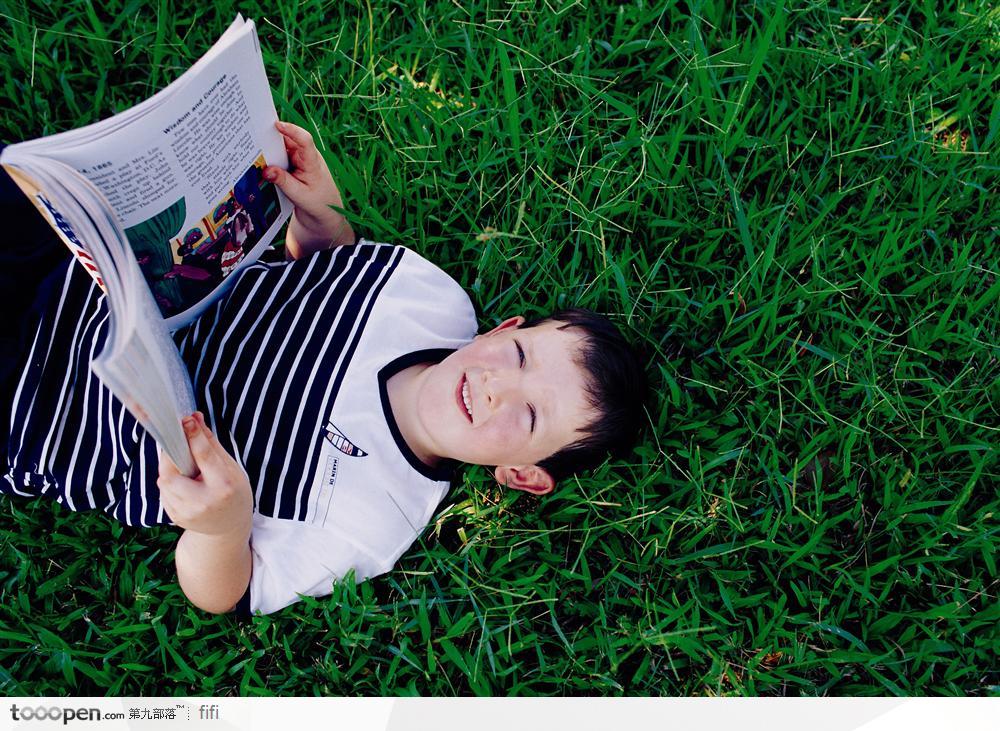 躺在草地上看书的小男孩