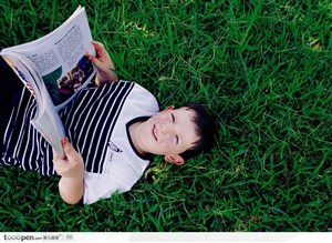 躺在草地上看书的小男孩