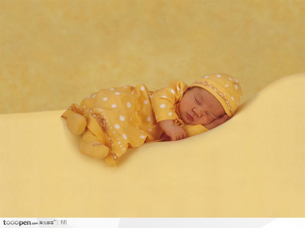 穿着黄色婴儿装熟睡的婴儿