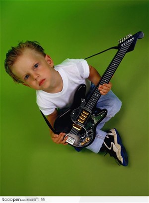绿地上拿着吉他的小男孩