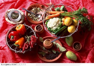 摆放在红桌布上的各种佐料和蔬菜水果