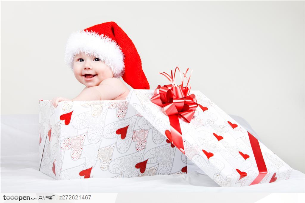 被装在红桃心礼品盒里带着圣诞老人帽子的外国婴儿