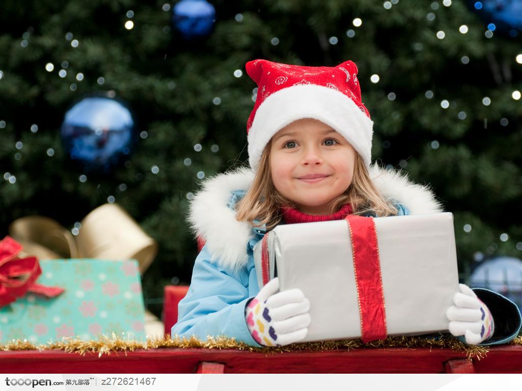 带着圣诞帽拿着礼品盒的外国可爱小女孩