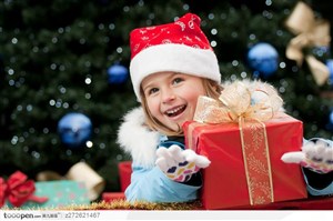带着圣诞帽闹着红色圣诞礼品盒的外国可爱小女孩