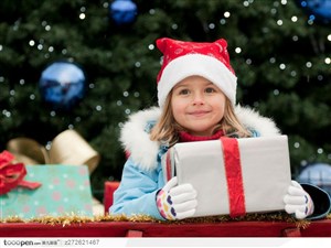 带着圣诞帽拿着礼品盒的外国可爱小女孩