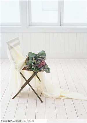 金属支架木椅子上的鲜花和白纱