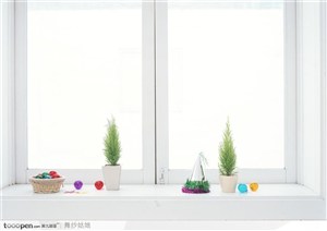 窗台上的两棵幼年圣诞树与彩色圣诞球