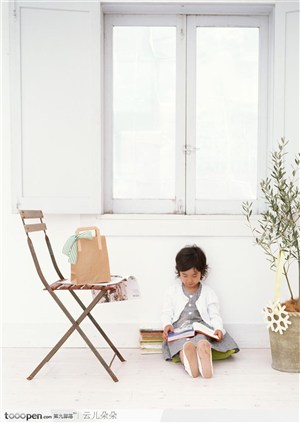 坐在窗台下面看书的小女孩