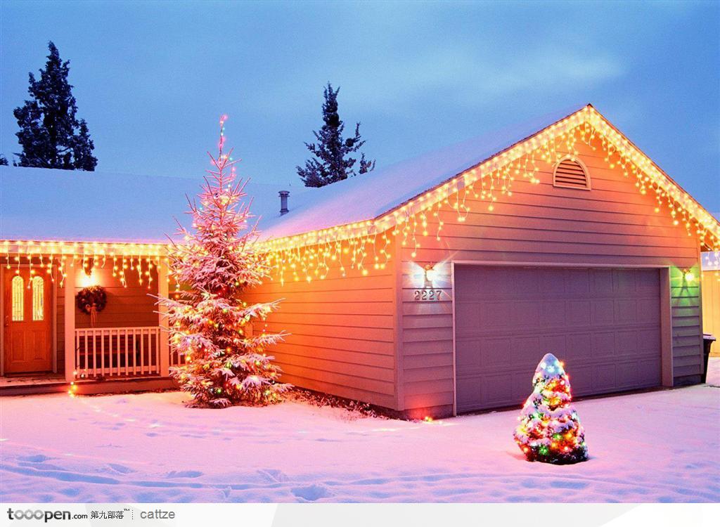 傍晚装饰着彩灯的房屋和屋前的圣诞树