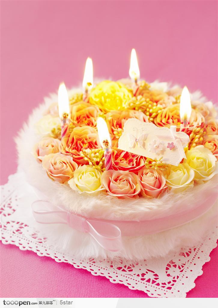 插满玫瑰花和蜡烛的生日蛋糕