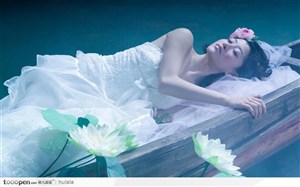 现代婚纱摄影照－－躺在荷花池塘船上的美女新娘