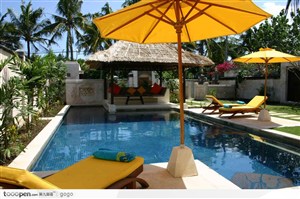 酒店游泳池旁太阳伞下的躺椅