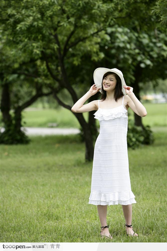 户外阳光美女-草地上双手执帽侧面照