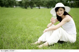 户外阳光美女-坐在草地上喝水正脸照 高清图片