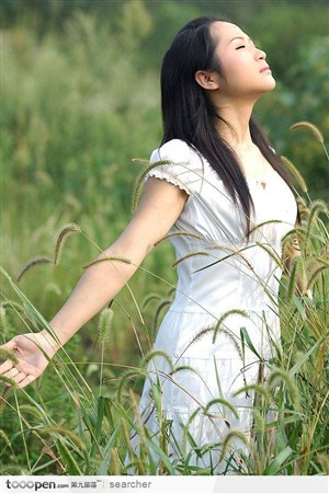 清纯美女站在草丛中呼吸新鲜空气的动作