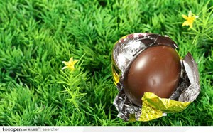 草地上金色锡纸包裹的巧克力复活节鸡蛋