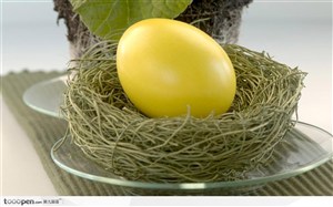 玻璃盘上鸟巢里的黄色复活节彩蛋