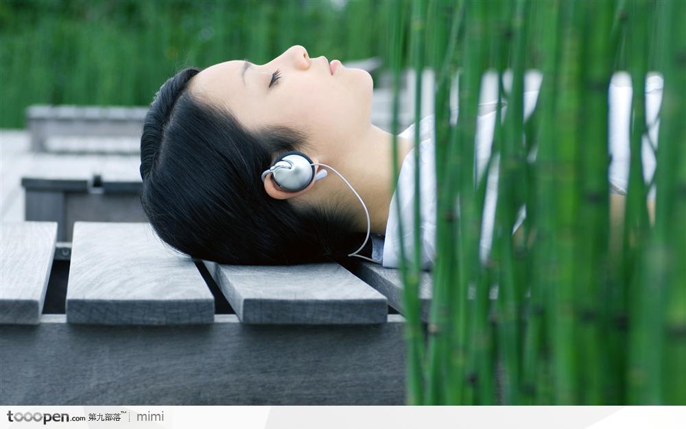 躺在木栈上听音乐的美女