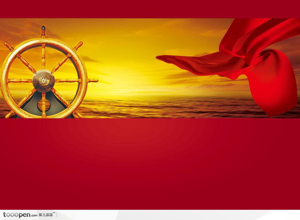 金黄色天空海面上巨大的海轮方向舵和飘动的红绸带
