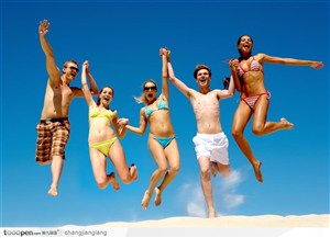 一群穿比基尼泳装的青年型男靓女在沙滩上玩耍 欢腾跳跃