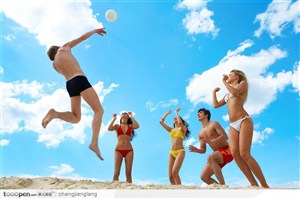 在沙滩上打排球的一群穿比基尼泳装的型男靓女