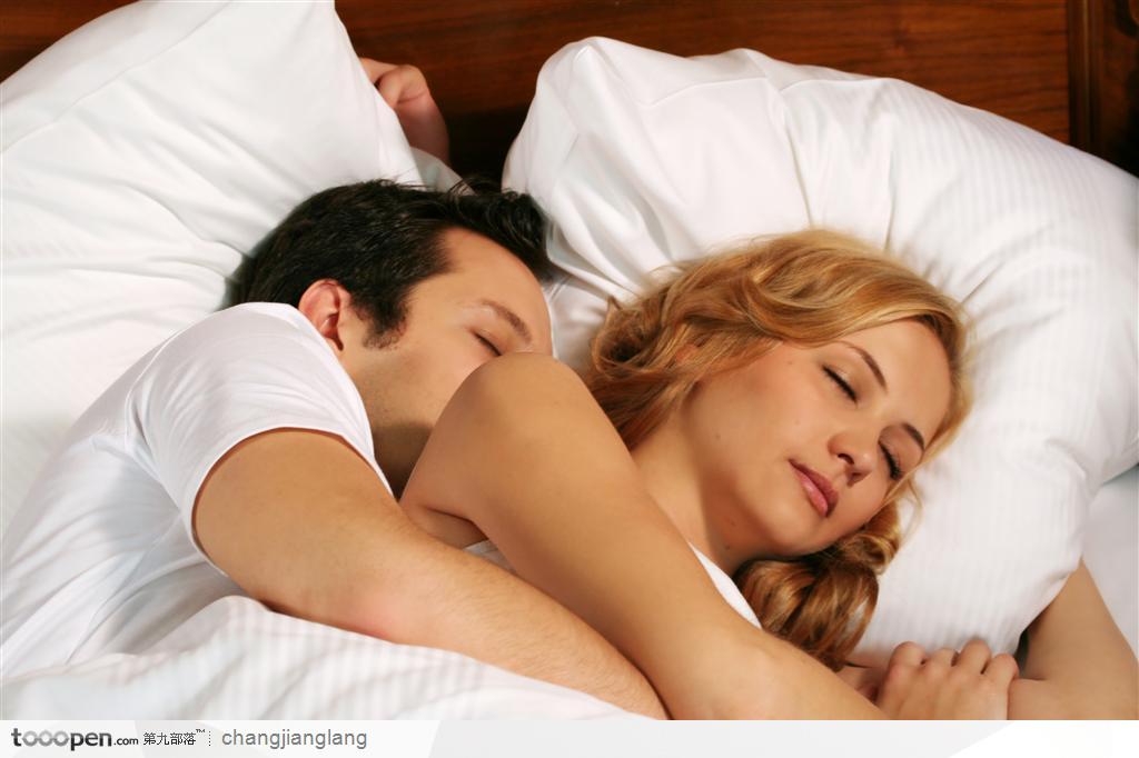 躺在床上相拥入眠的情侣夫妻