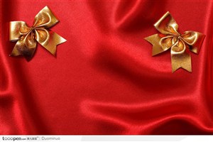 红色背景红绸布上的两个金色蝴蝶结