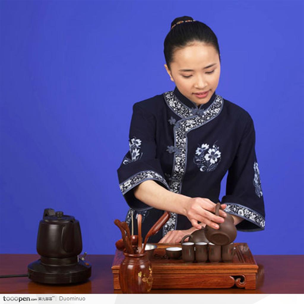 中国传统茶艺-拿着紫砂茶壶滤茶的女性