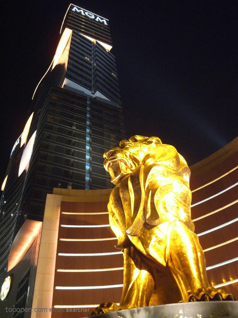 繁华城市夜景建筑前的铜狮子