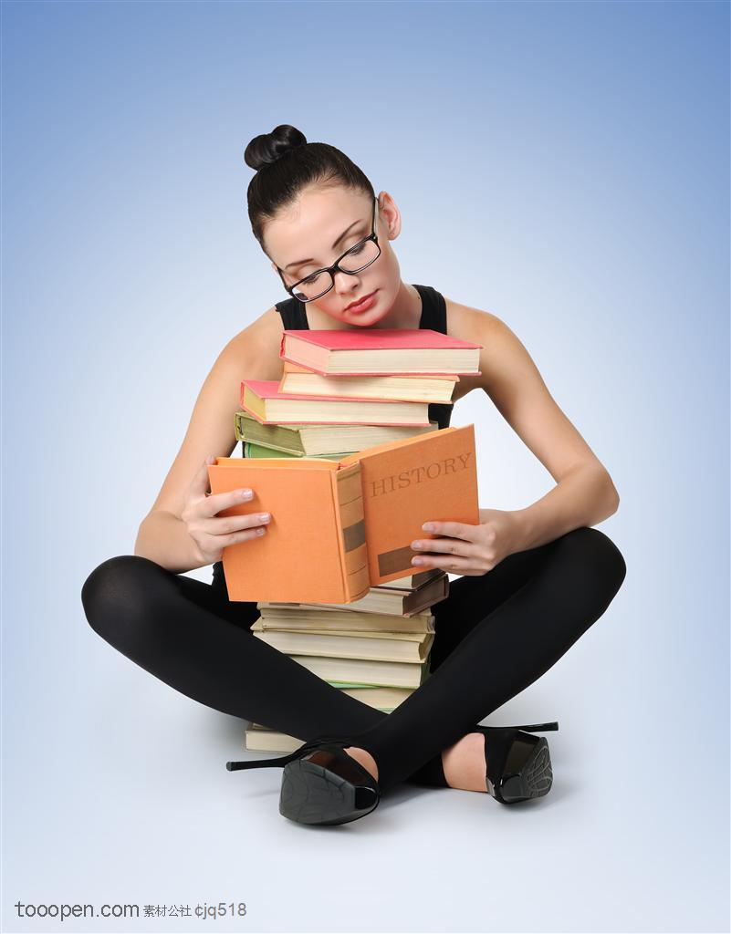 坐着抱着一堆书看书的女大学生图片素材