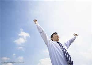 蓝天下双手举起朝气蓬勃的企业员工图片