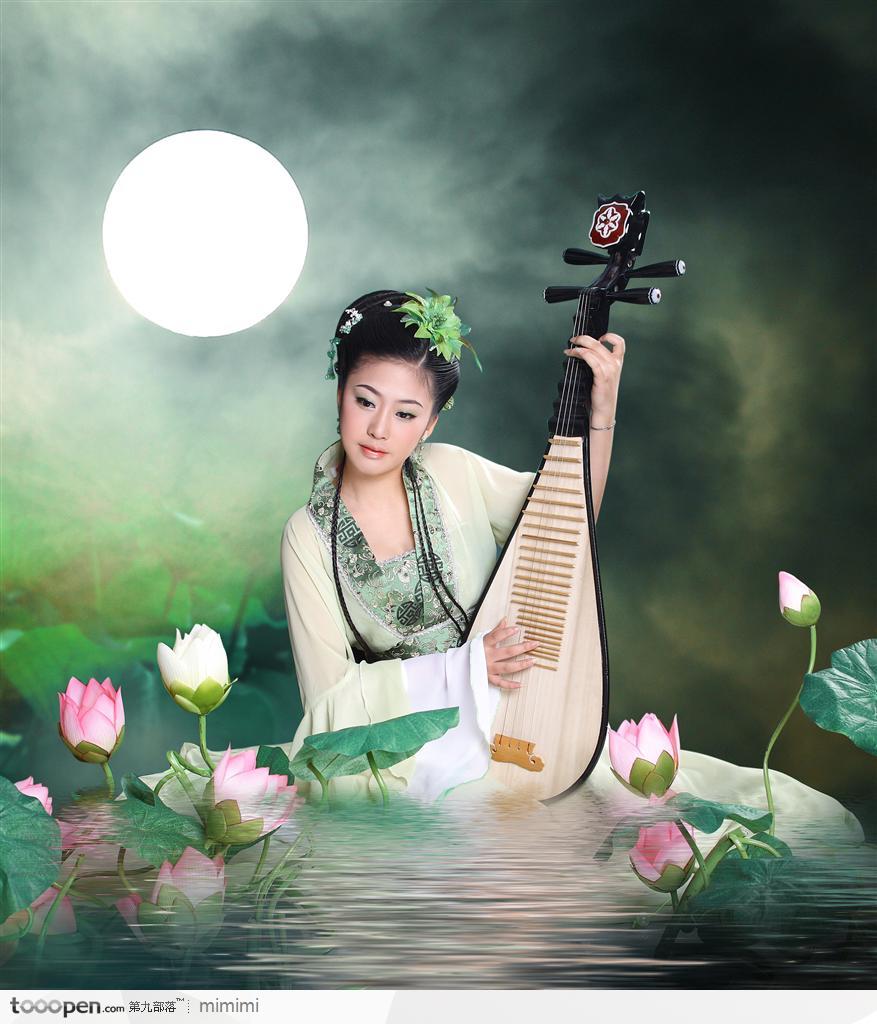 穿传统汉服坐在荷花池边弹琵琶的古典美女