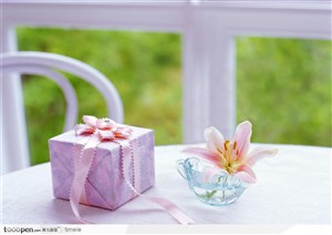花园中白色桌子上的精美礼物包和玻璃杯子的花朵