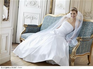 坐在欧式沙发上穿白色婚纱的气质美女