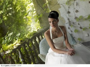 穿白色婚纱坐在阳台上的高贵气质美女