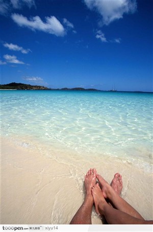 海滩休闲生活-蓝天下的沙滩与脚