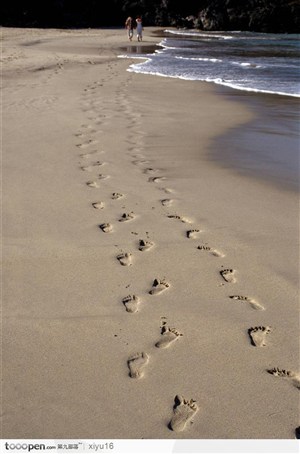 海滩休闲生活-沙滩上的两排脚印