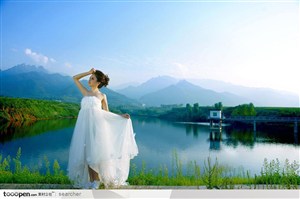 站在湖边穿白色婚纱礼服的美女新娘