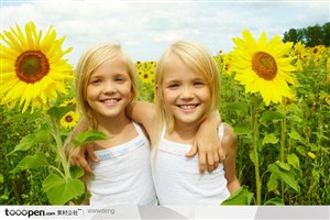 金发外国小孩拿着向日葵的双胞胎女孩