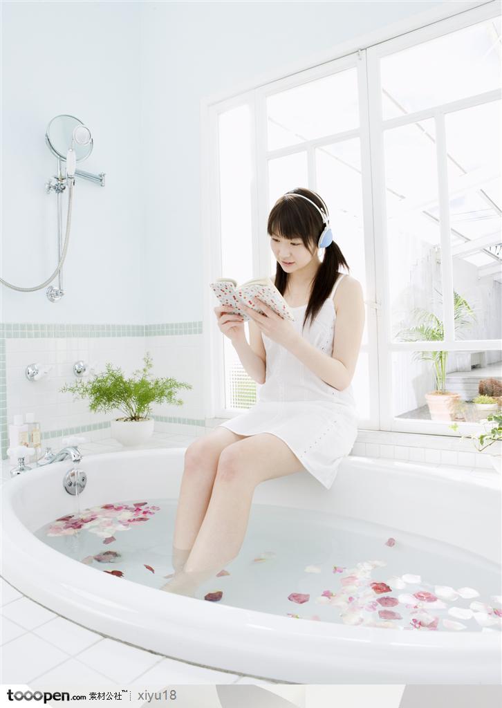 女性休闲-坐着浴缸上听歌看书的美女