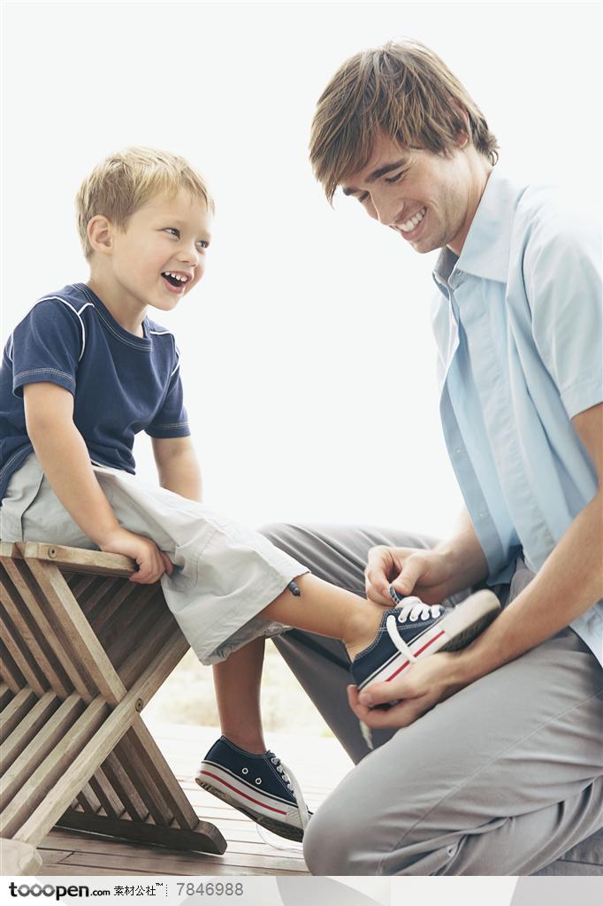 幸福家庭-外国家庭爸爸为儿子穿鞋子