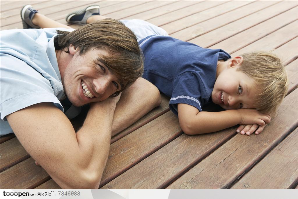 幸福家庭-外国家庭用手做枕头趴在地上的父子俩