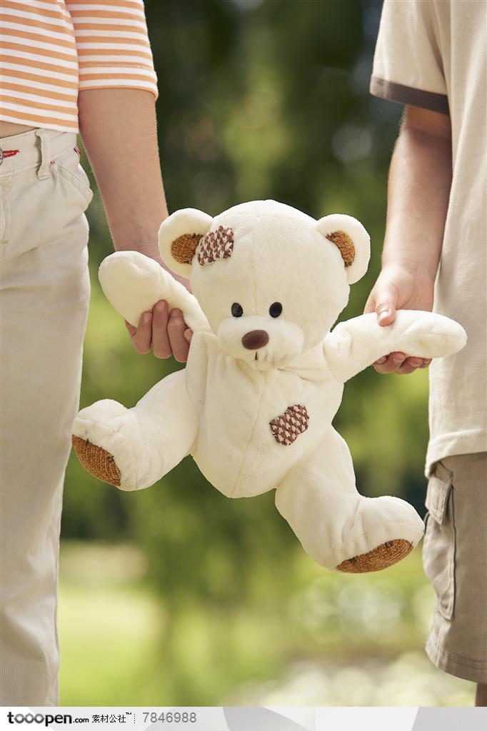 幸福家庭-国外家庭母子两拉着毛绒玩具熊的手