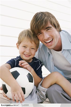 幸福家庭-外国家庭怀里搂着足球的男孩和爸爸开怀大笑